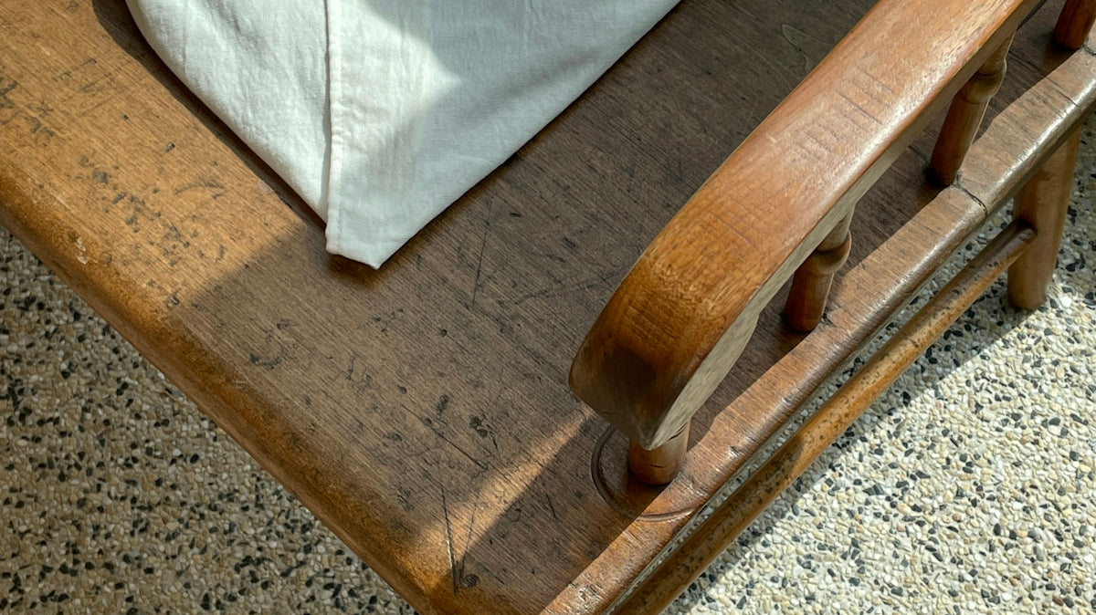 a wooden chair with a white cloth on top of it