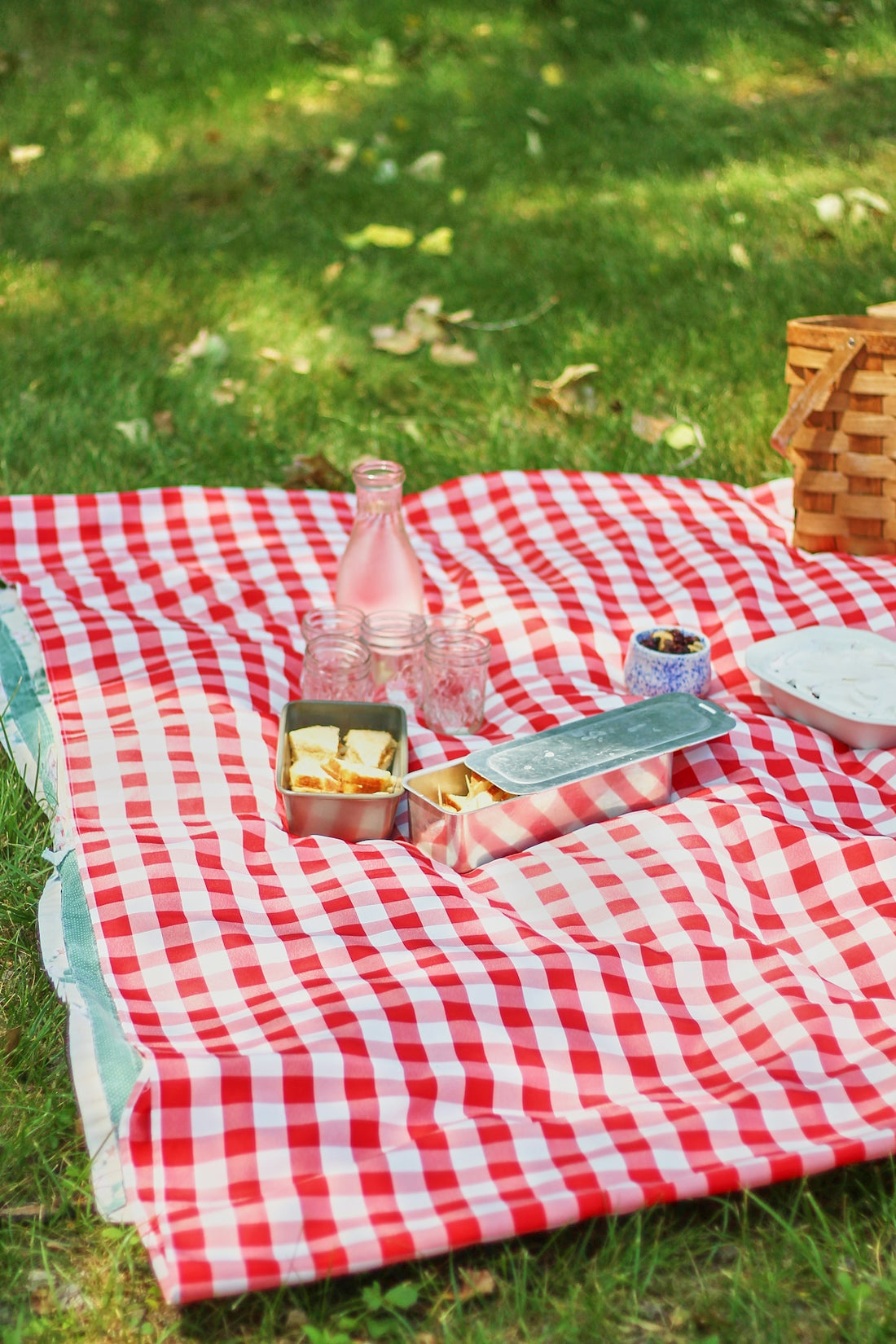 A picnic blanket with food and drinks on it