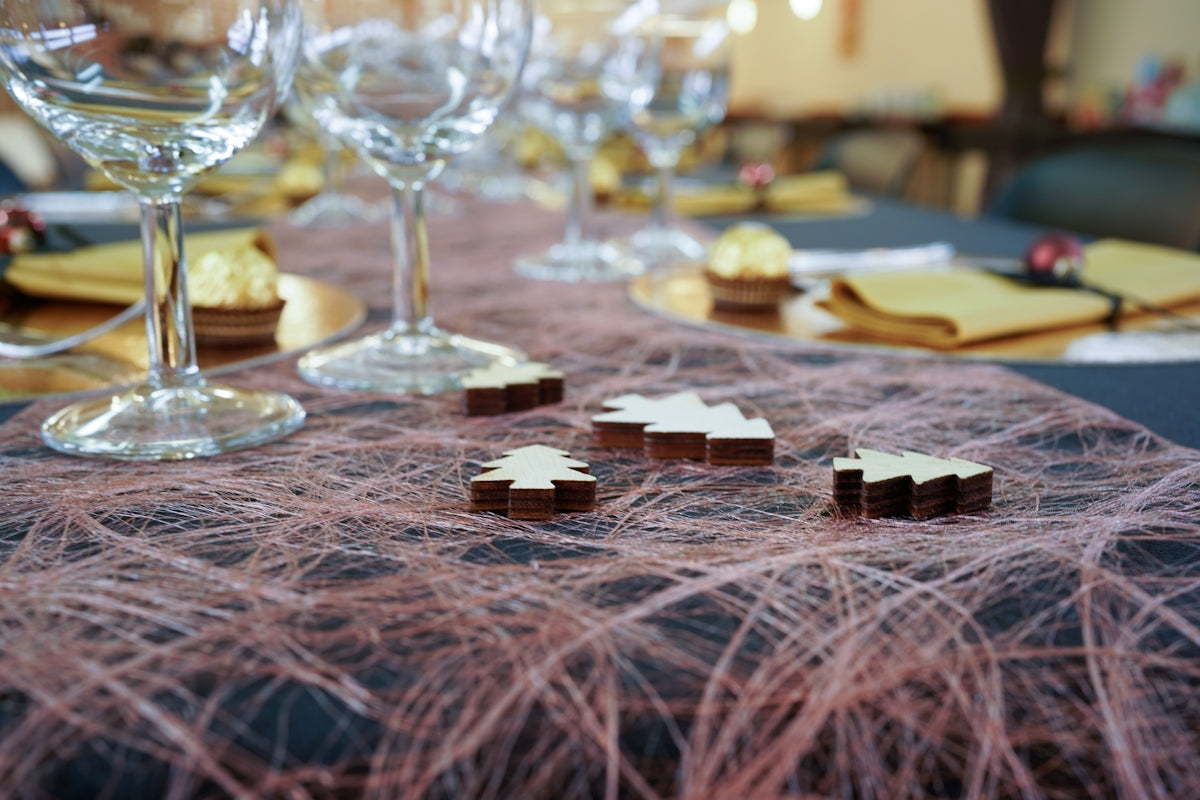 macro photography of small beige Christmas tree decorations near long-stem wine glasses