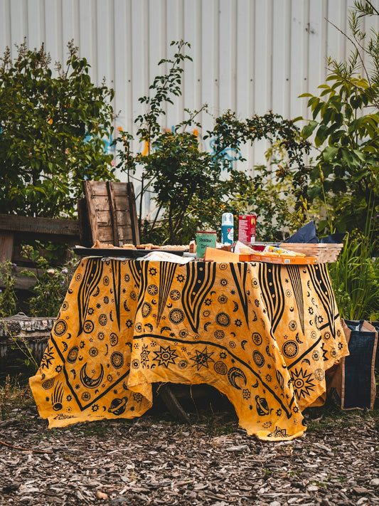a table with a yellow cloth and a basket of food on it