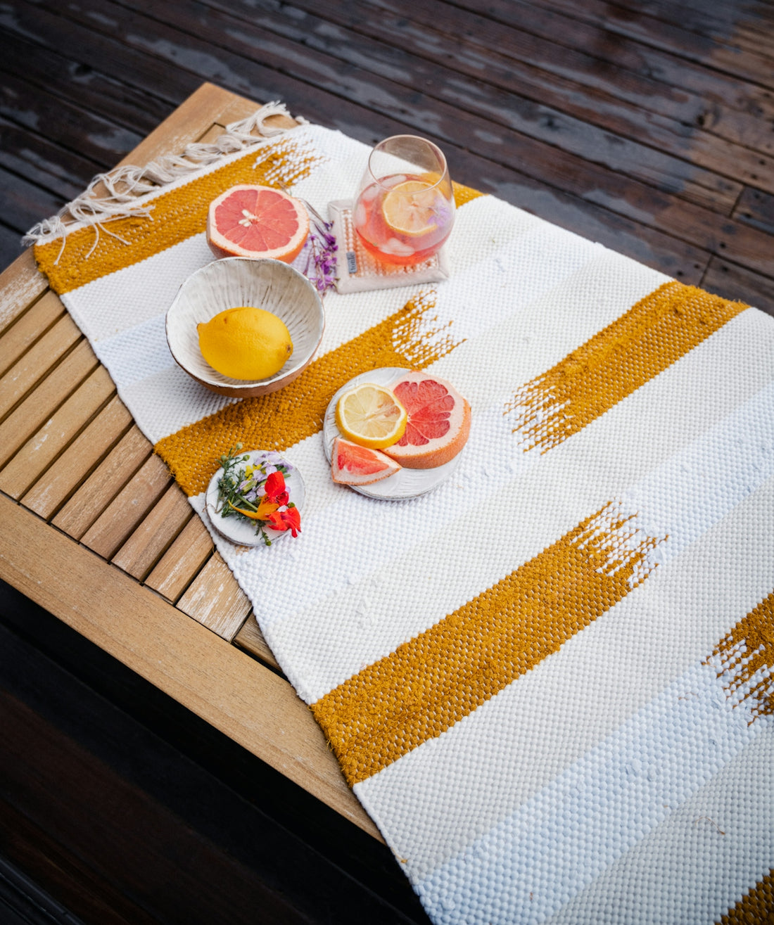 a table topped with a bowl of fruit next to a bowl of oranges