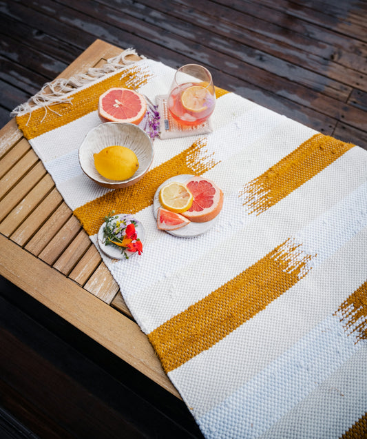 a table topped with a bowl of fruit next to a bowl of oranges