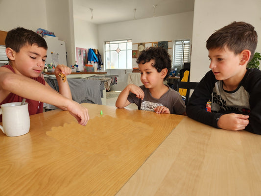 a group of young boys sitting around a wooden table