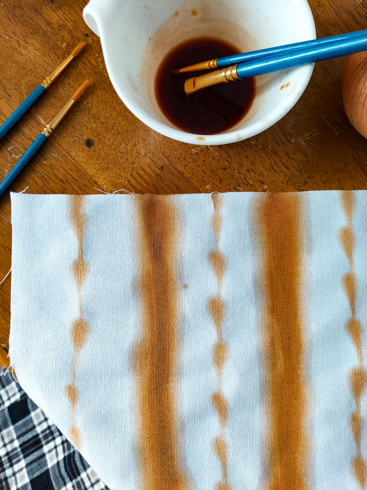 a bowl of brown liquid next to a pair of scissors