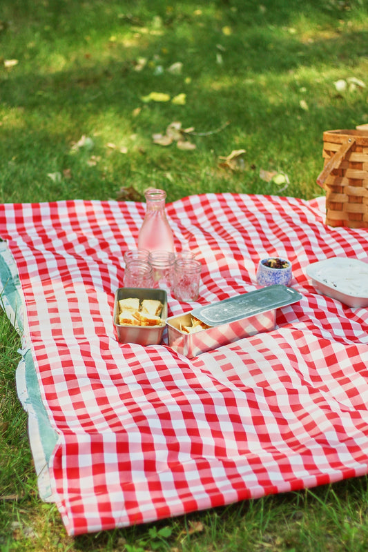 A picnic blanket with food and drinks on it