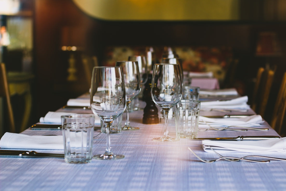 A long table with glasses and napkins on it