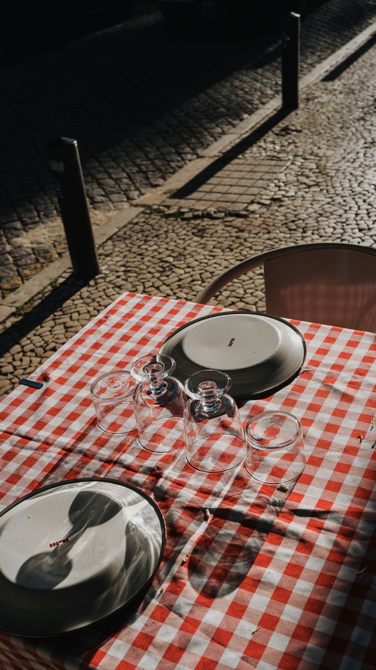Plates and glasses sit on a checkered tablecloth.