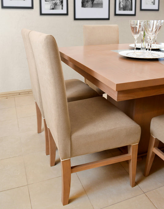 Dining table with upholstered chairs and place settings.